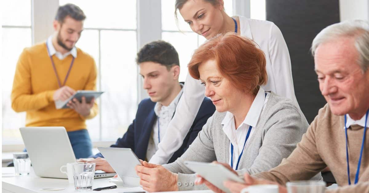 une femme debout avec une femme rousse assisie et un jeune homme