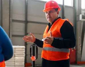 homme en gilet fluo orange et portant un casque orange à rouvroy