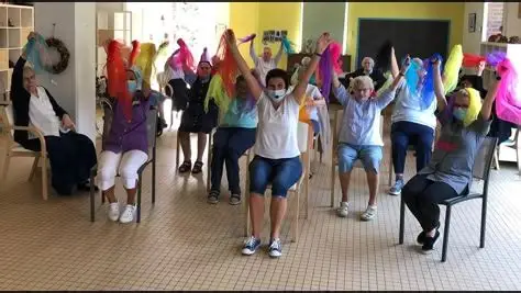 Groupe de participants assis en cercle, levant des foulards colorés lors d’un atelier CREADIAZ animé par VD FORMATIONS, favorisant la créativité et le bien‑être au travail.